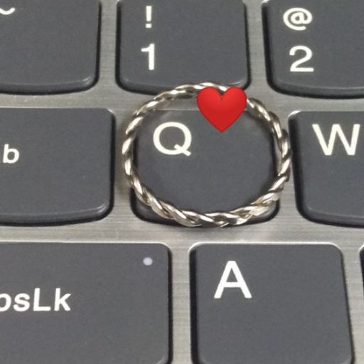 A ring with a small red heart on the _Q_ key of a computer keyboard