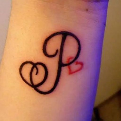 A tattoo of a fancy letter 'P' with a small red heart on a person's wrist