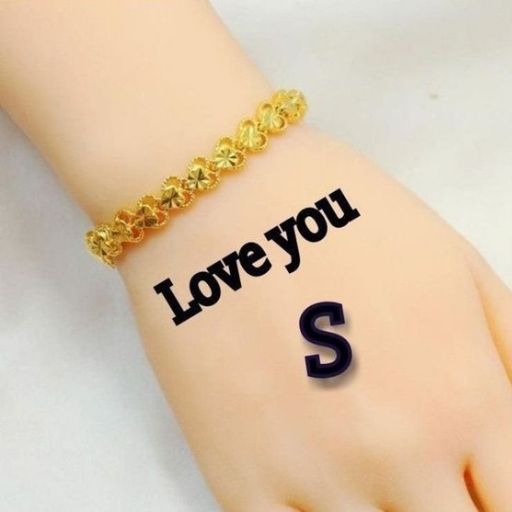 A wrist with a gold bracelet and _Love you S_ tattooed on it