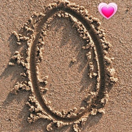 An oval shape drawn in the sand with a pink heart emoji above it