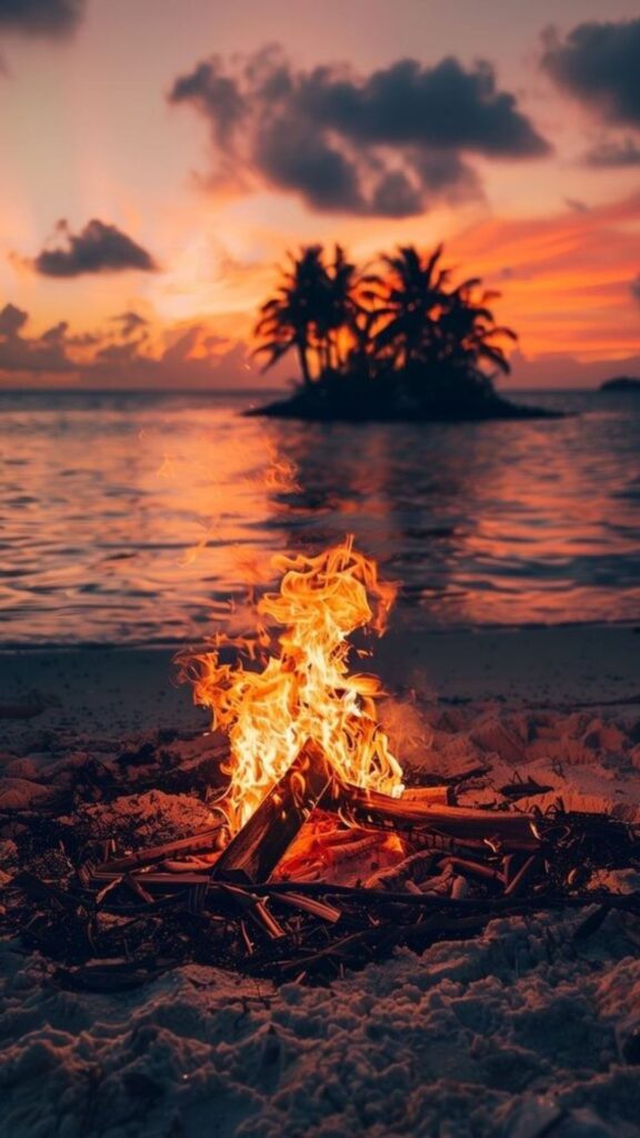 Beach campfire at dusk with a small island and orange sky in the background