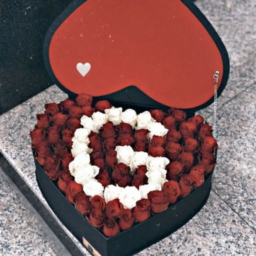 Heart-shaped box with red and white roses arranged to form a larger heart