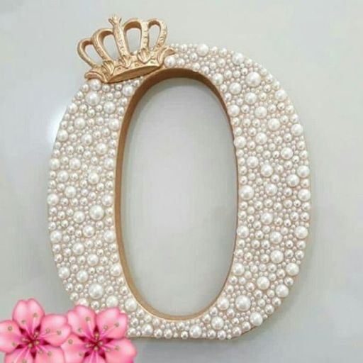 Ornate oval frame adorned with pearls and a small crown on top, against a neutral background