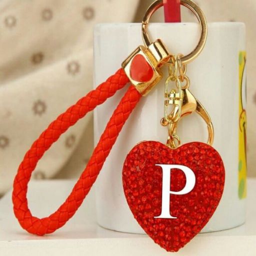 Red heart keychain with letter 'P' attached to a mug handle