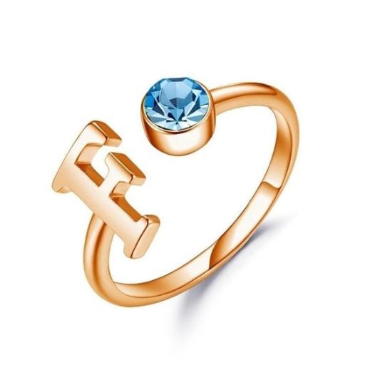 Rose gold ring with a blue gemstone and an anchor design on a white background