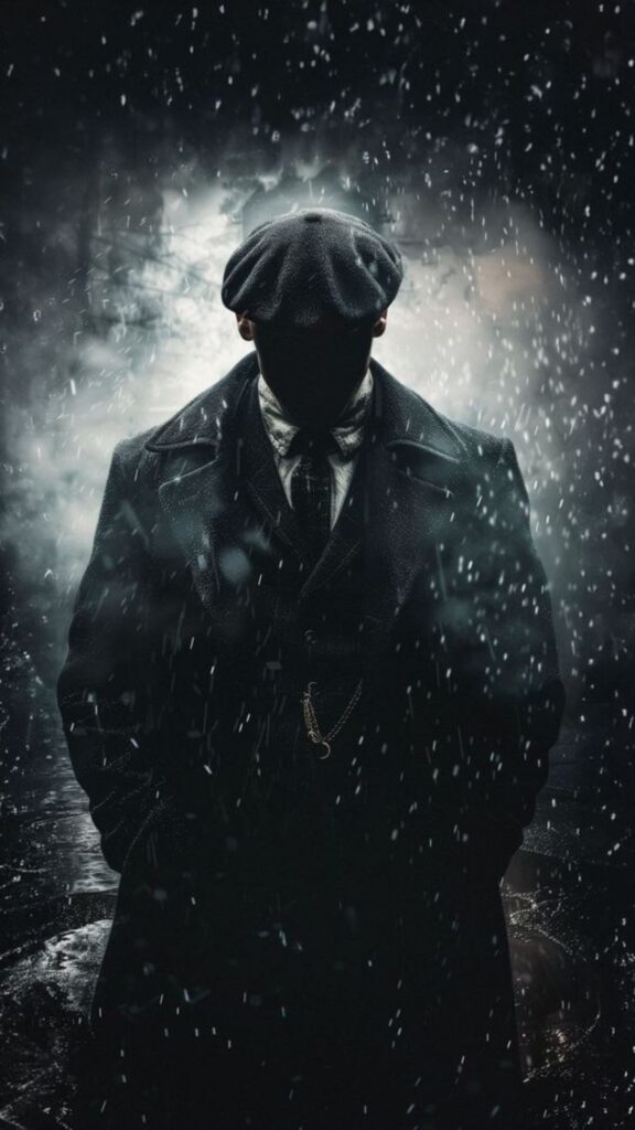 Silhouette of a person in trench coat and cap against a snowy backdrop