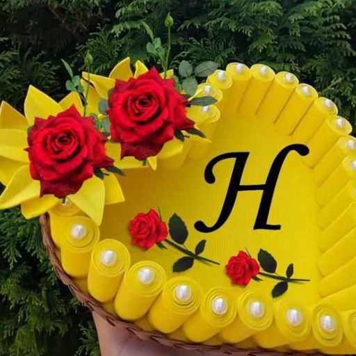 Yellow cap with letter 'H', adorned with red roses and origami, against a green foliage background