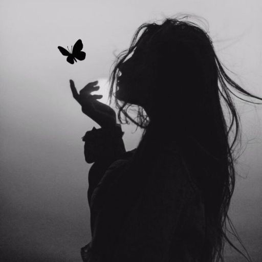 a black and white photo of a woman holding a butterfly