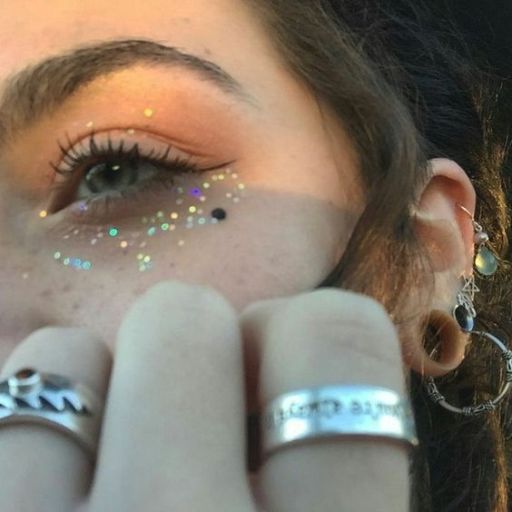 a close up of a person with rings on their fingers