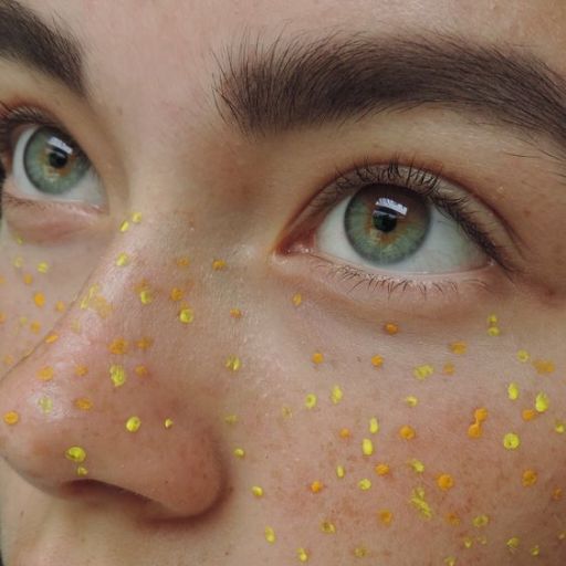 a close up of a person with yellow speckles on their face