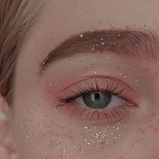 a close up of a person's eye with glitter on it