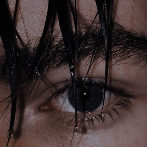 a close up of a person's eye with wet hair