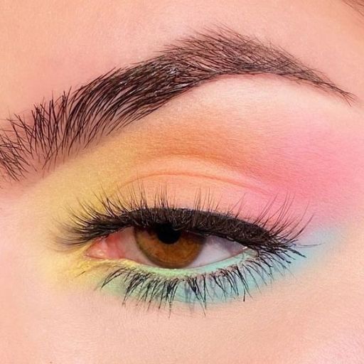 a close up of a woman's eye with bright makeup