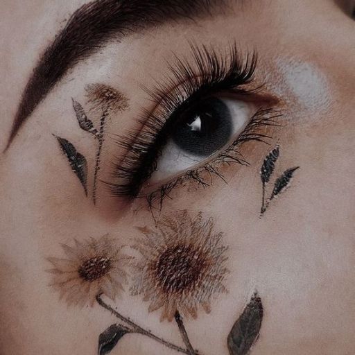 a close up of a woman's eye with flowers on it