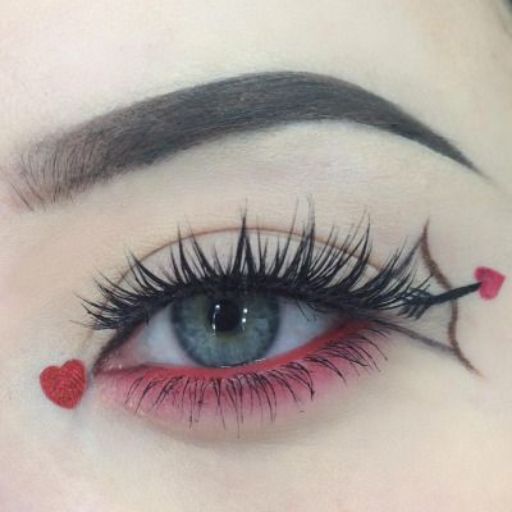 a close up of a woman's eye with red hearts on her lashes