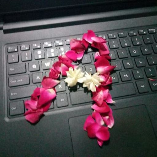 a computer keyboard with a bunch of pink and white flowers on it