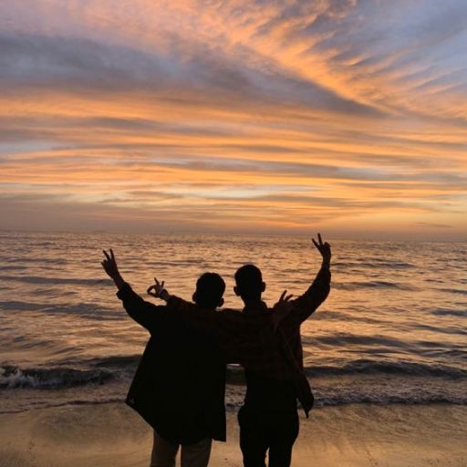 a couple of people standing on top of a beach