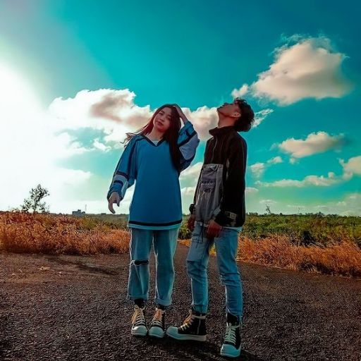 a couple of people standing on top of a dirt road