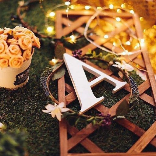 a cup of flowers sitting on top of a lush green field