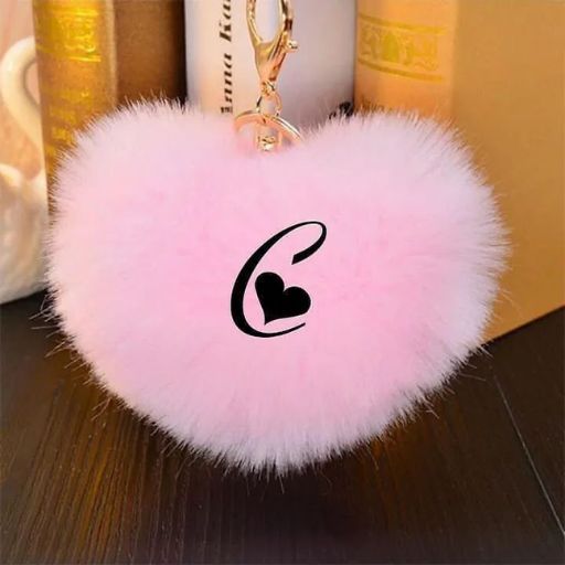 a fluffy pink heart shaped keychain on a table