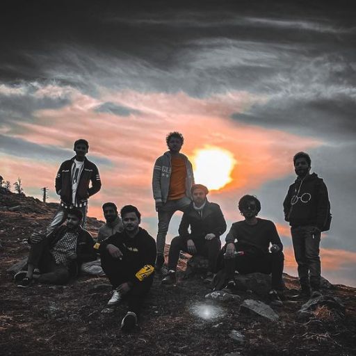 a group of people sitting on top of a mountain