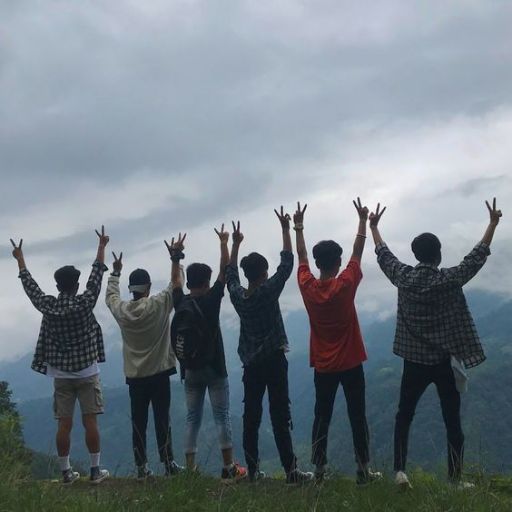 a group of people standing on top of a lush green hillside