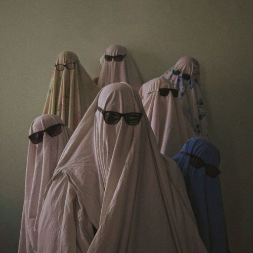 a group of people wearing white veils and sunglasses