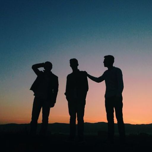 a group of three men standing next to each other