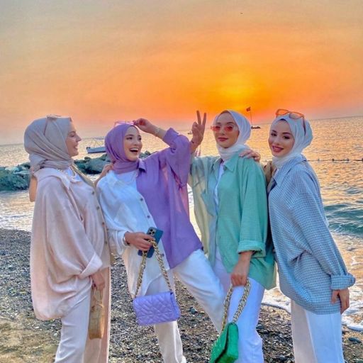 a group of women standing next to each other on a beach