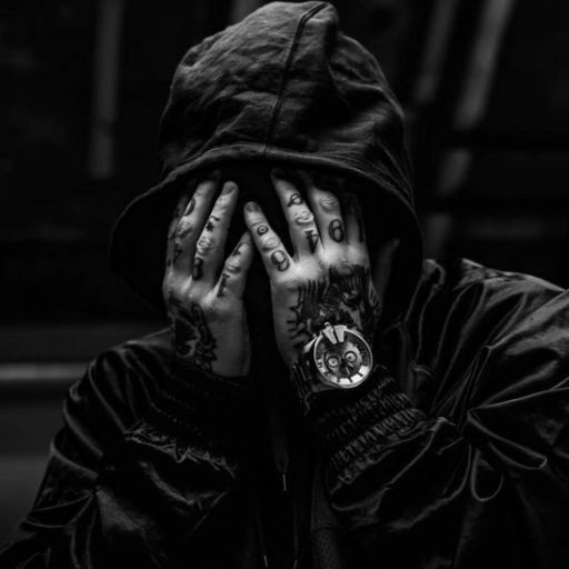 a man with tattoos covering his face with his hands