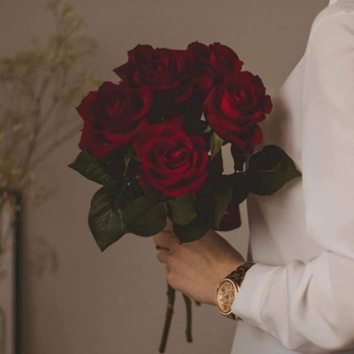 a person holding a bouquet of red roses