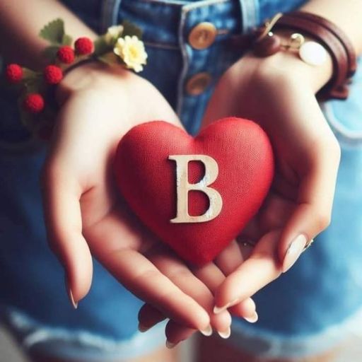 a person holding a heart with the letter b on it