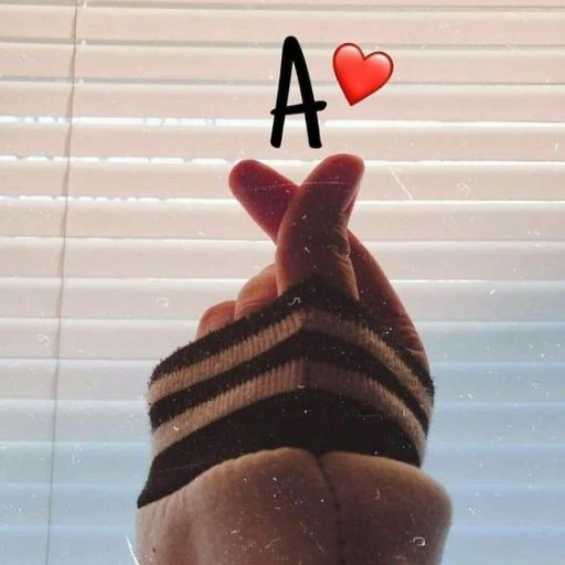 a person holding up a hand with the letter a in front of a window