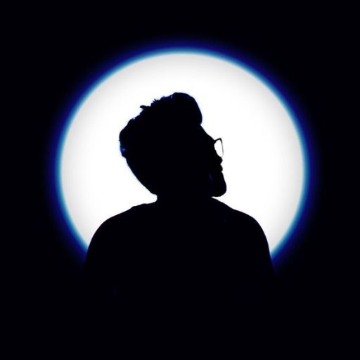 a silhouette of a man in front of a light