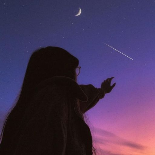 a woman looking up at the sky at night