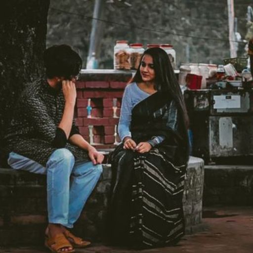 a woman sitting next to a man on a bench