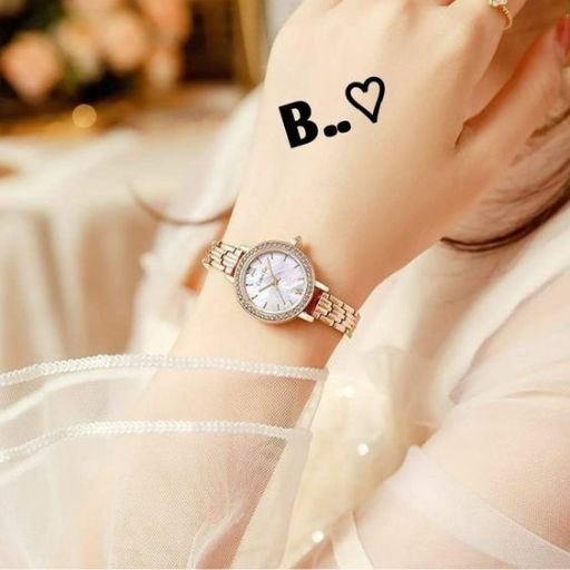 a woman wearing a watch with the letter b on her wrist