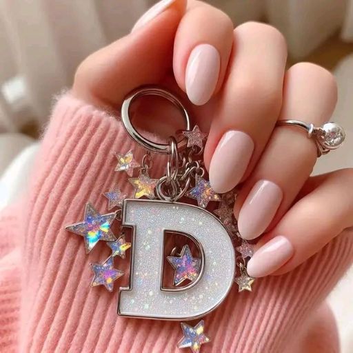 a woman's hand holding a key chain with the letter d on it