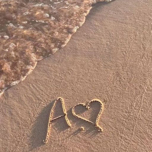 two hearts drawn in the sand on a beach