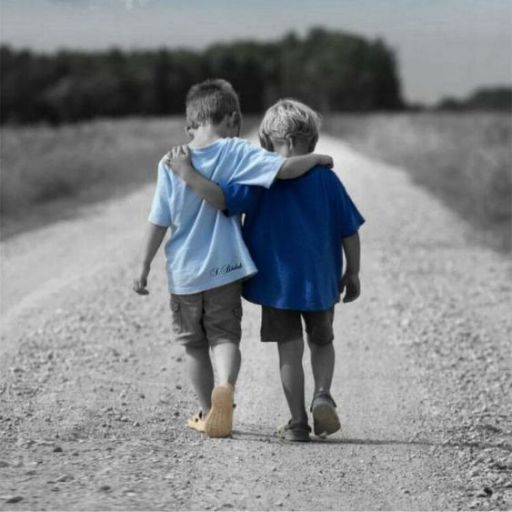 two young boys walking down a dirt road