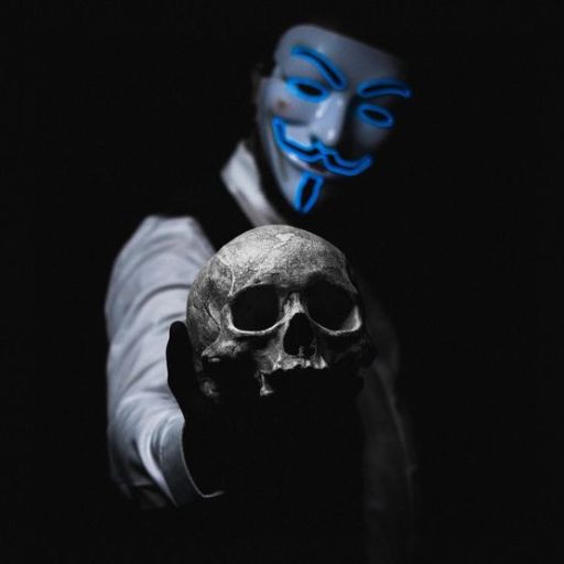 A hand holding a skull against a dark background