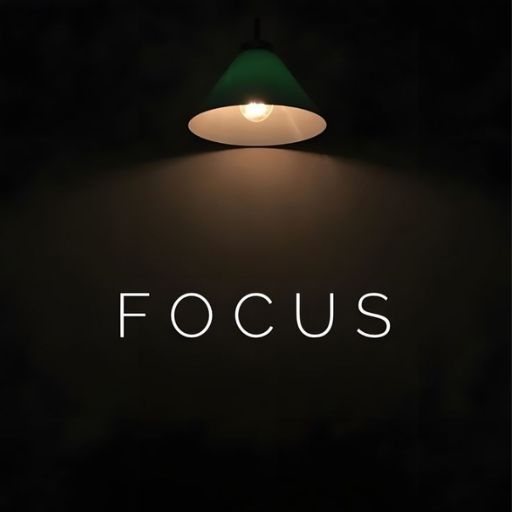 A hanging lamp illuminates the word _FOCUS_ on a dark background