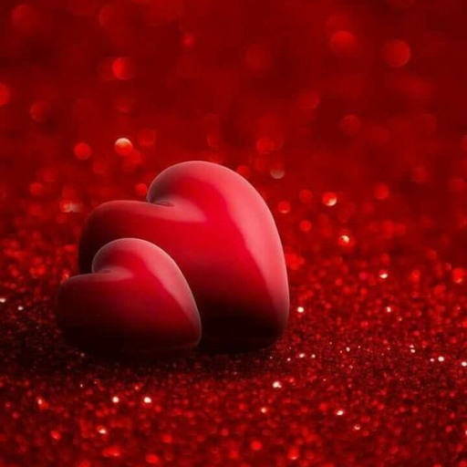 A red heart-shaped object on a sparkling red glitter background