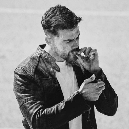 Man in a leather jacket lighting a cigarette, black and white photo