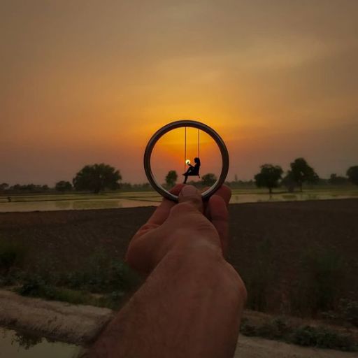 Person framed within a small circle against a sunset background