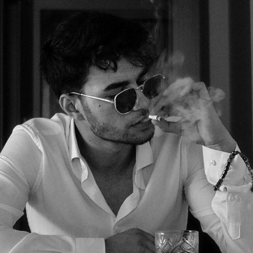 Person in a white shirt exhaling smoke with a bracelet on the wrist