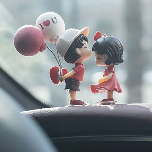 Two cartoon figurines of a boy and girl about to kiss, boy holding heart-shaped balloons, on a car dashboard