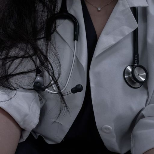 A close-up of a medical professional wearing a white coat and stethoscope