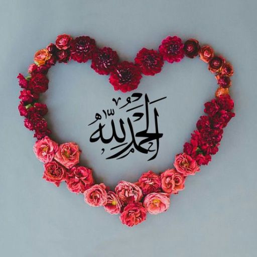 A heart shape formed by red and pink flowers with Arabic calligraphy in the center