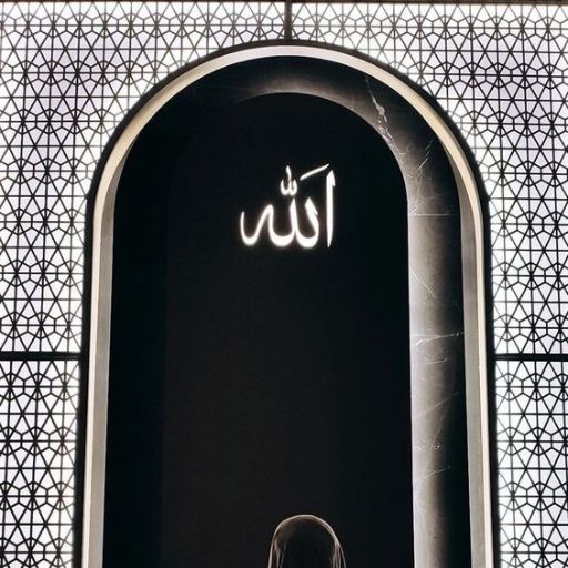 A person standing before an arched doorway with the Arabic word _Allah_ illuminated above+